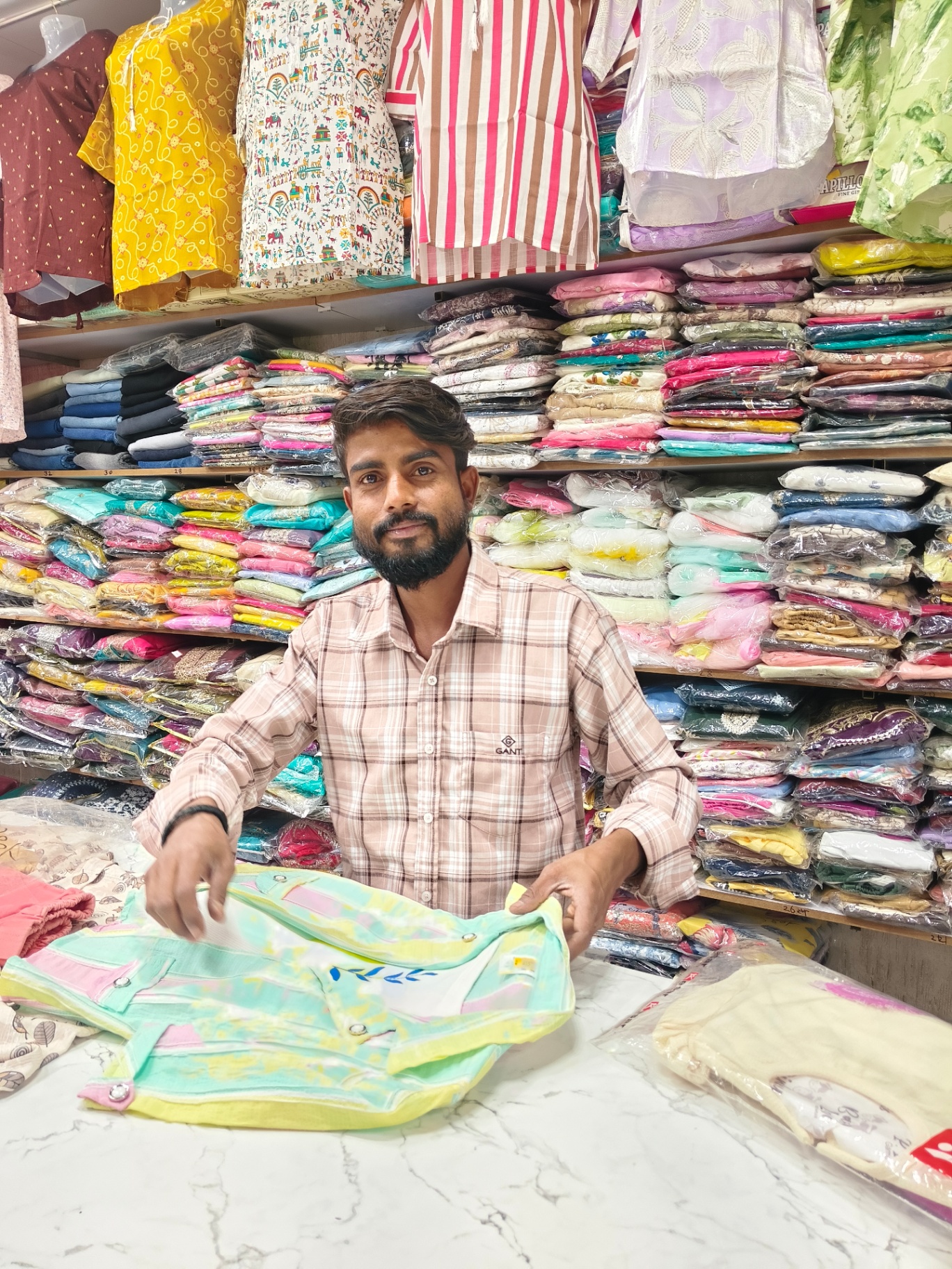 Friendly staff member presenting clothing at Fashion Street
